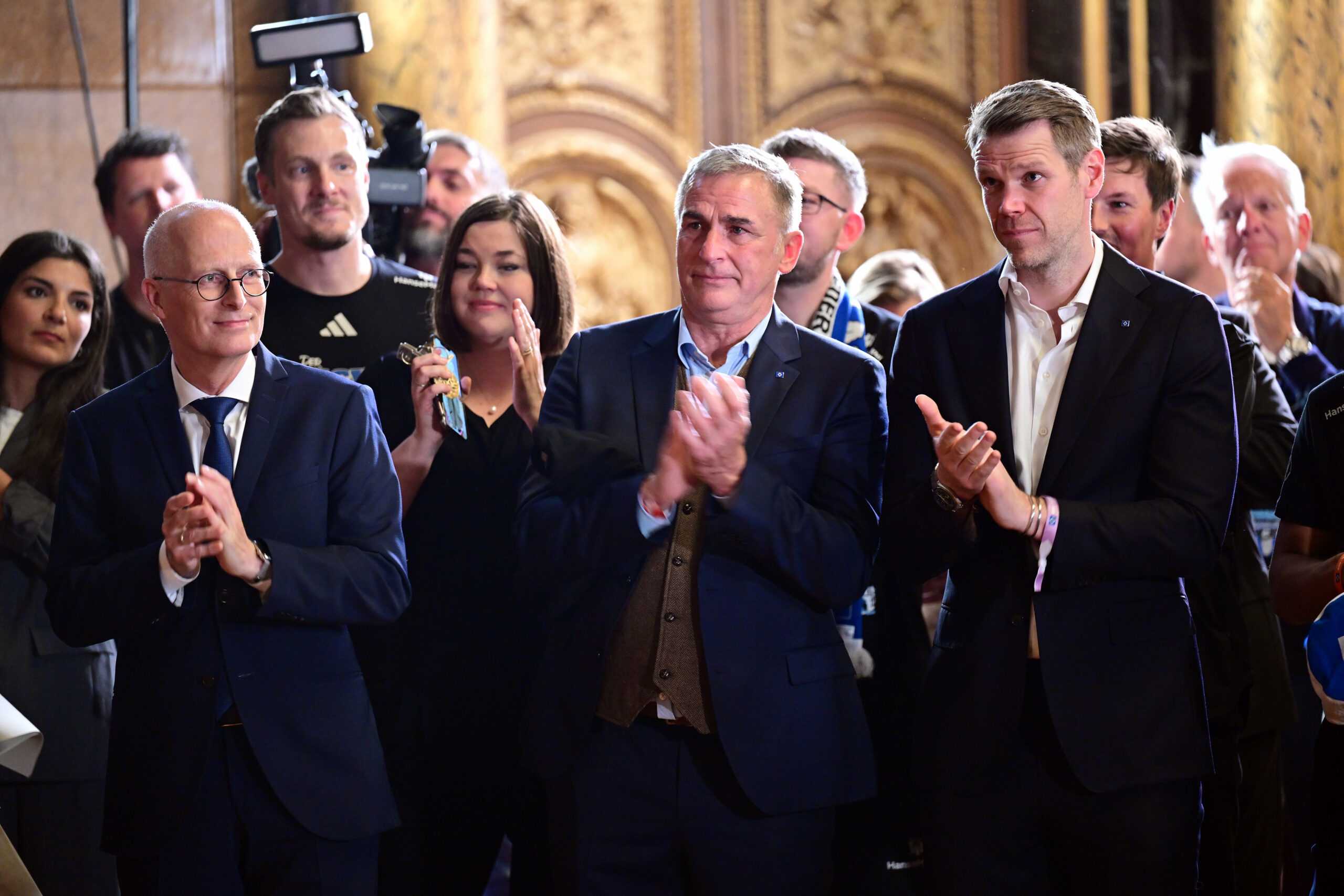 Peter Tschentscher, Stefan Kuntz und Eric Huwer applaudieren beim Rathaus-Empfang für den HSV
