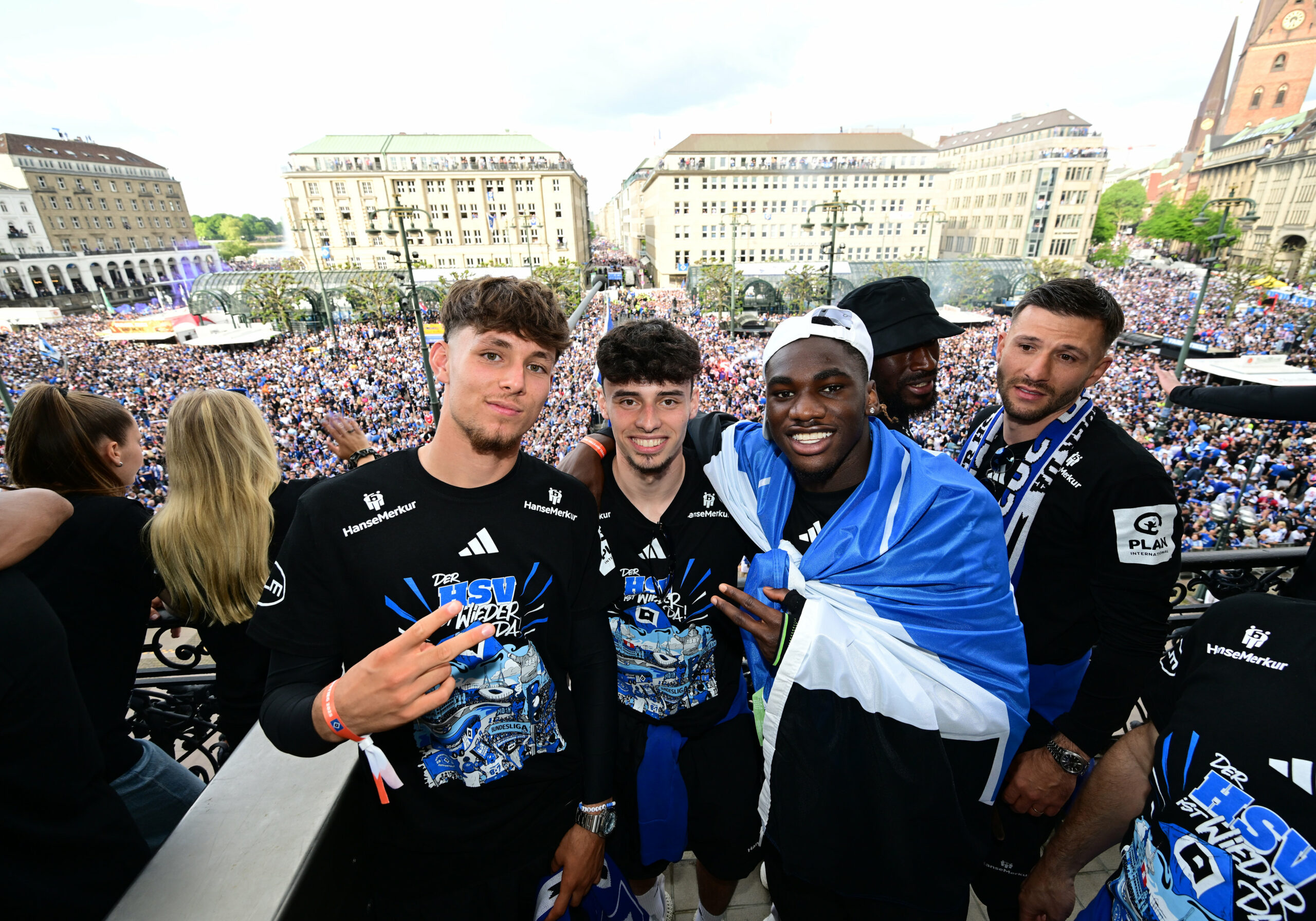 Otto Stange, Nicolas Oliveira und Fabio Baldé lächeln auf dem Rathaus-Balkon in die Kamera