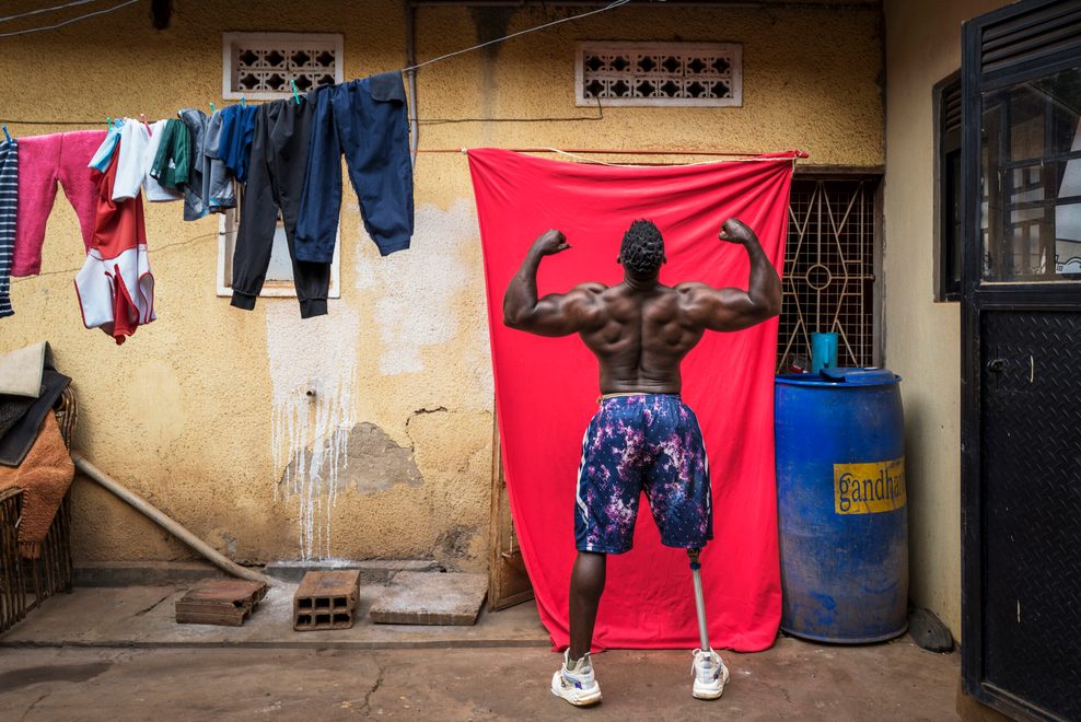 Ein Bodybuilder posiert im Hinterhof eines Hauses.