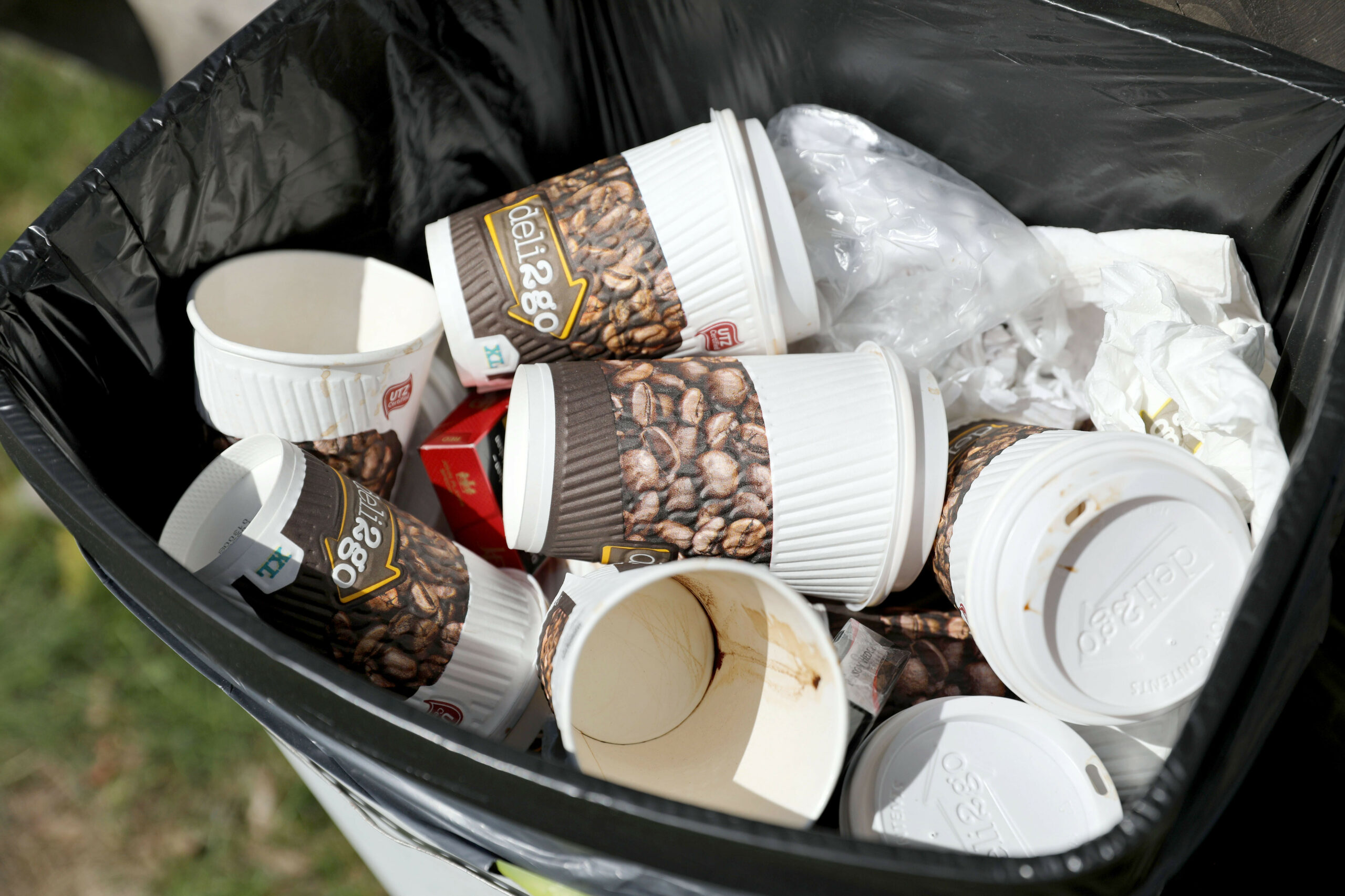 Leere Einwegbecher in einem Mülleimer – BUND fordert Verpackungssteuer. (Symbolbild)