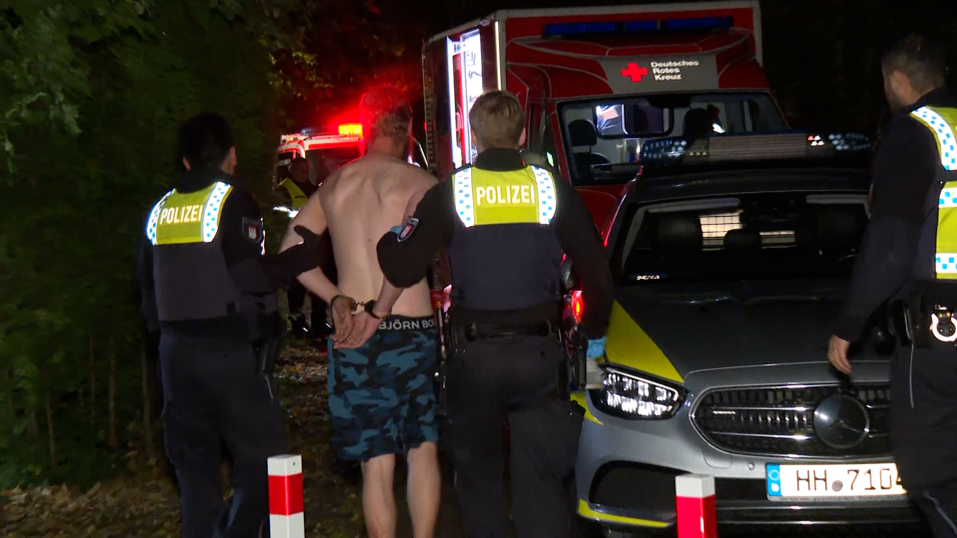 Polizisten führen einen Tatverdächtigen in Stellingen ab.