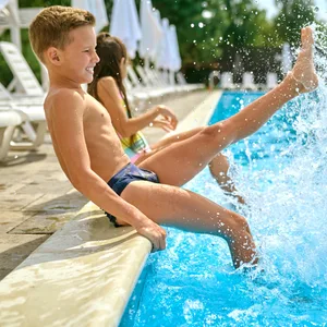 Zwei Kinder planschen im Pool.