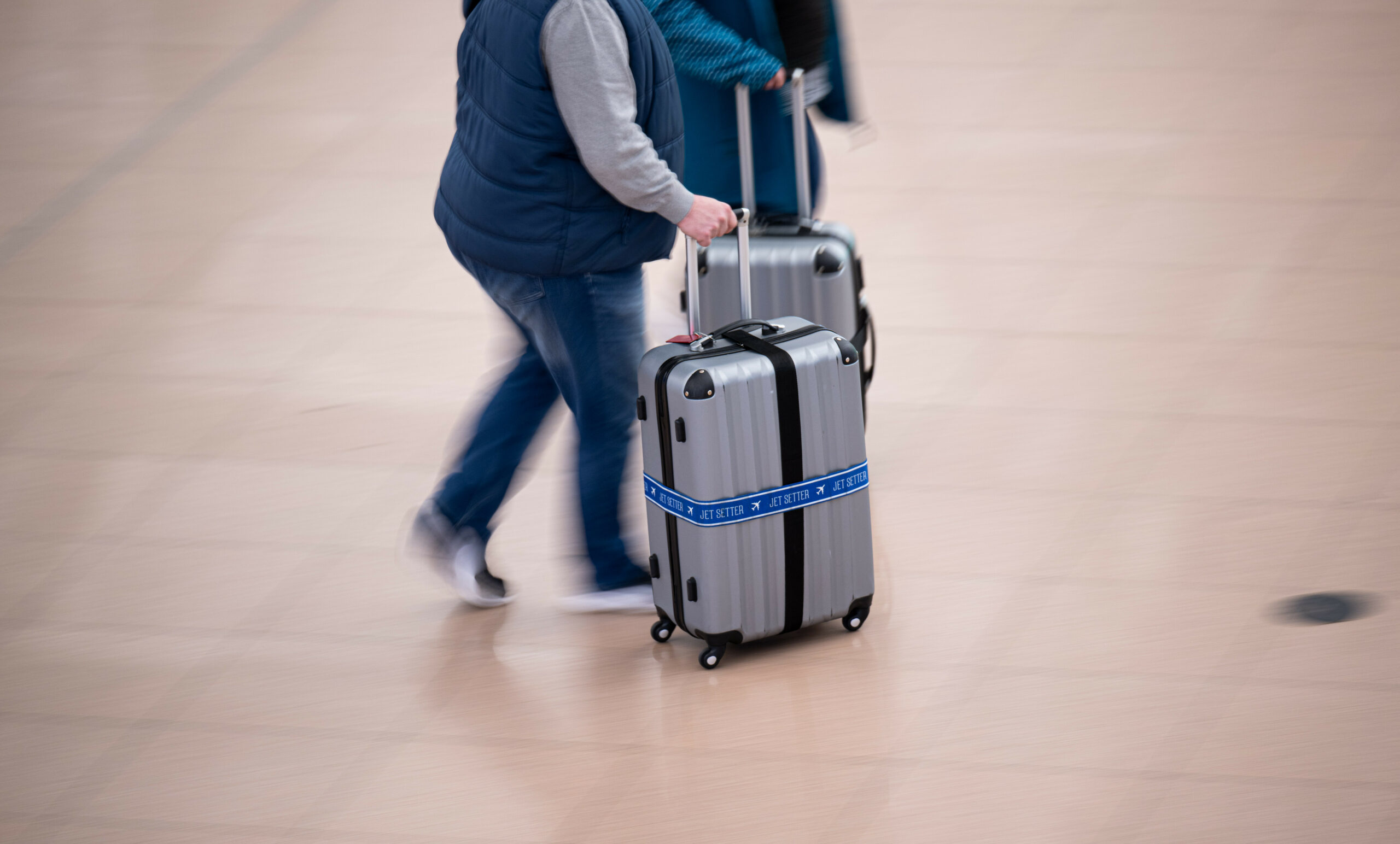 Flugreisende gehen mit ihren Koffern durch den Flughafen Hamburg.
