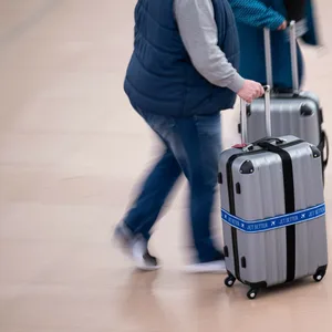 Flugreisende gehen mit ihren Koffern durch den Flughafen Hamburg.