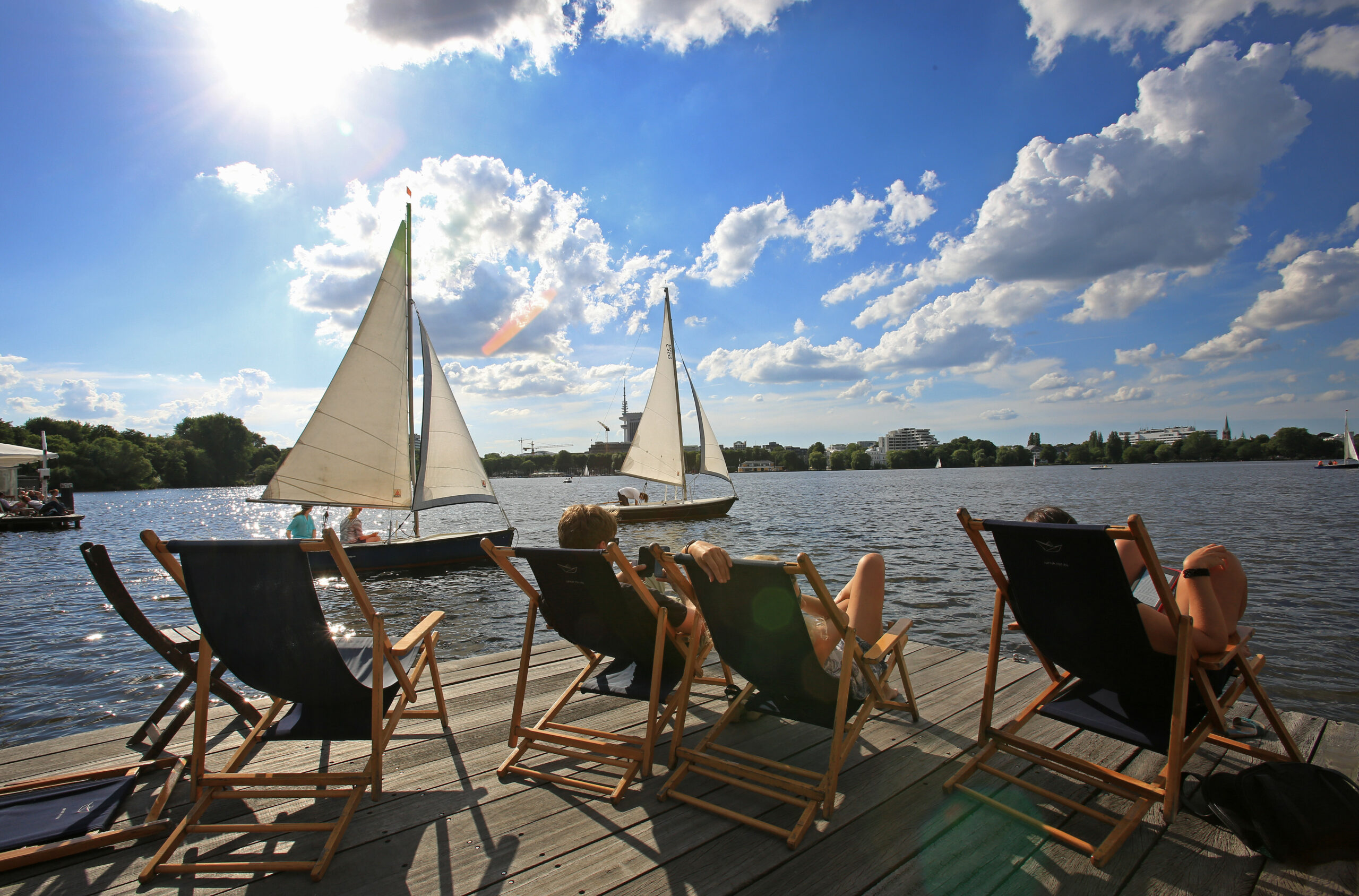 Menschen sonnen sich an der Alster