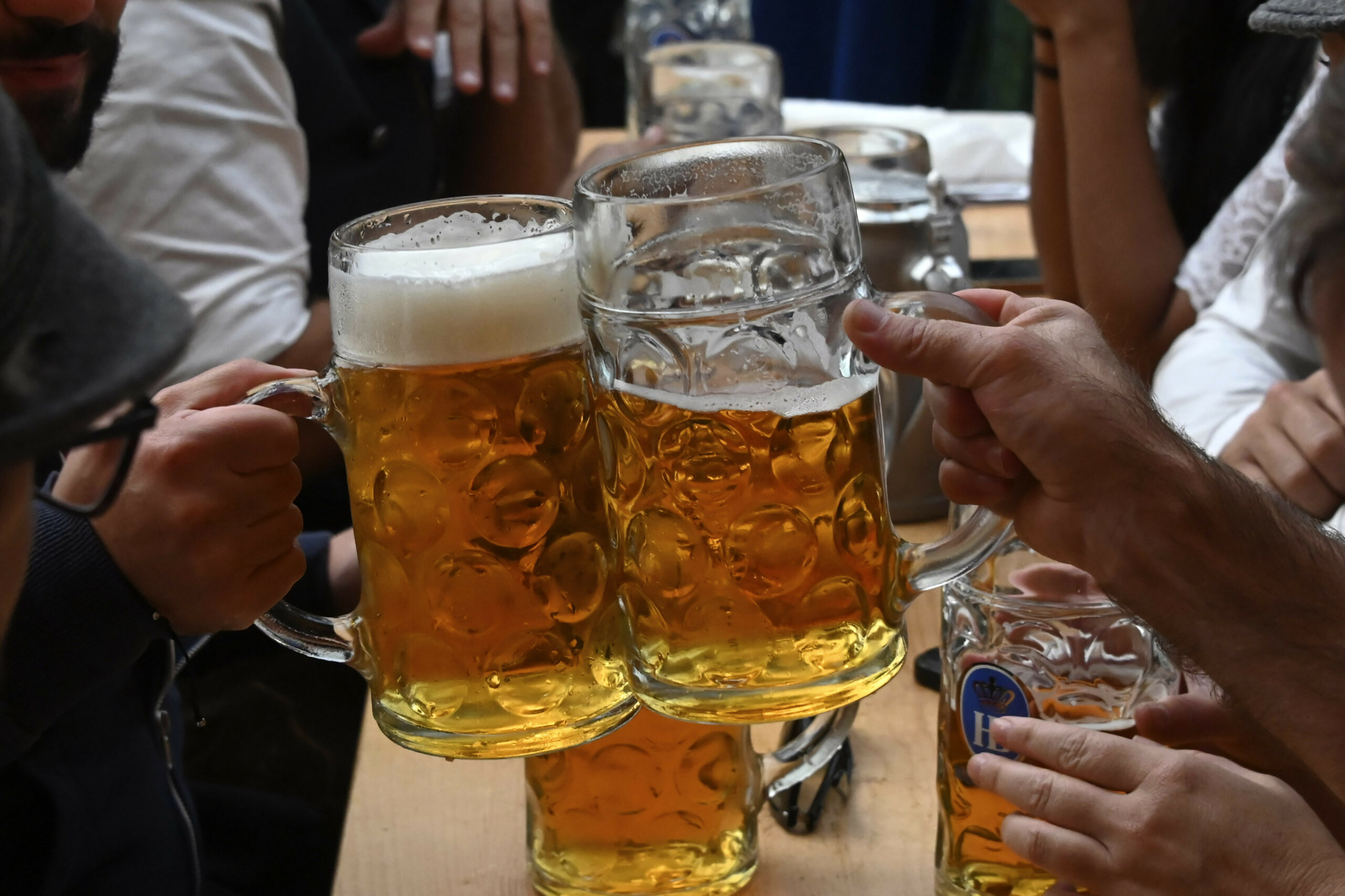 Zwei Menschen stoßen mit Bier an (Symbolbild)