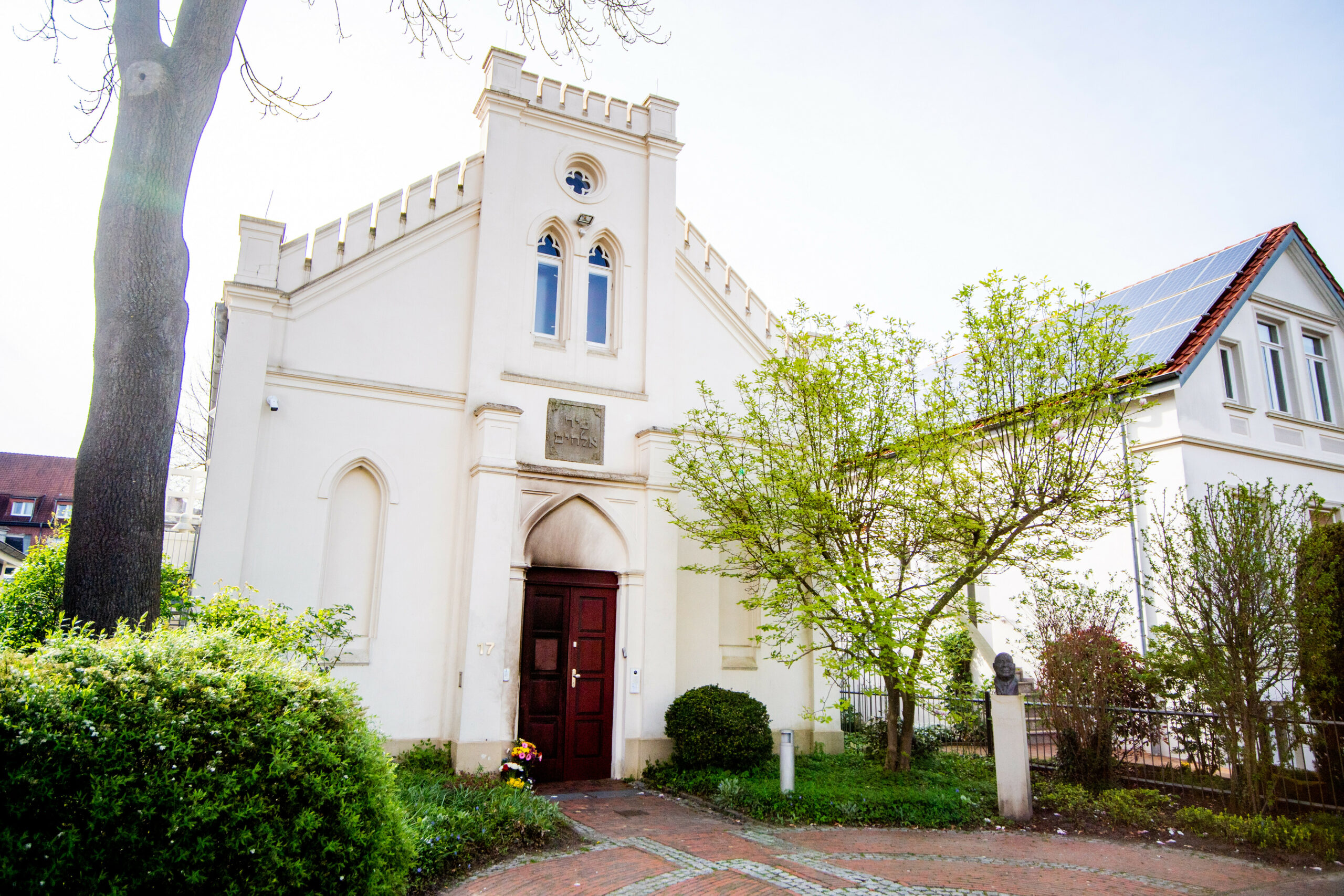 Blumen und Kerzen stehen vor der Synagoge im Stadtzentrum in Oldenburg, auf die der Brandanschlag verübt wurde.