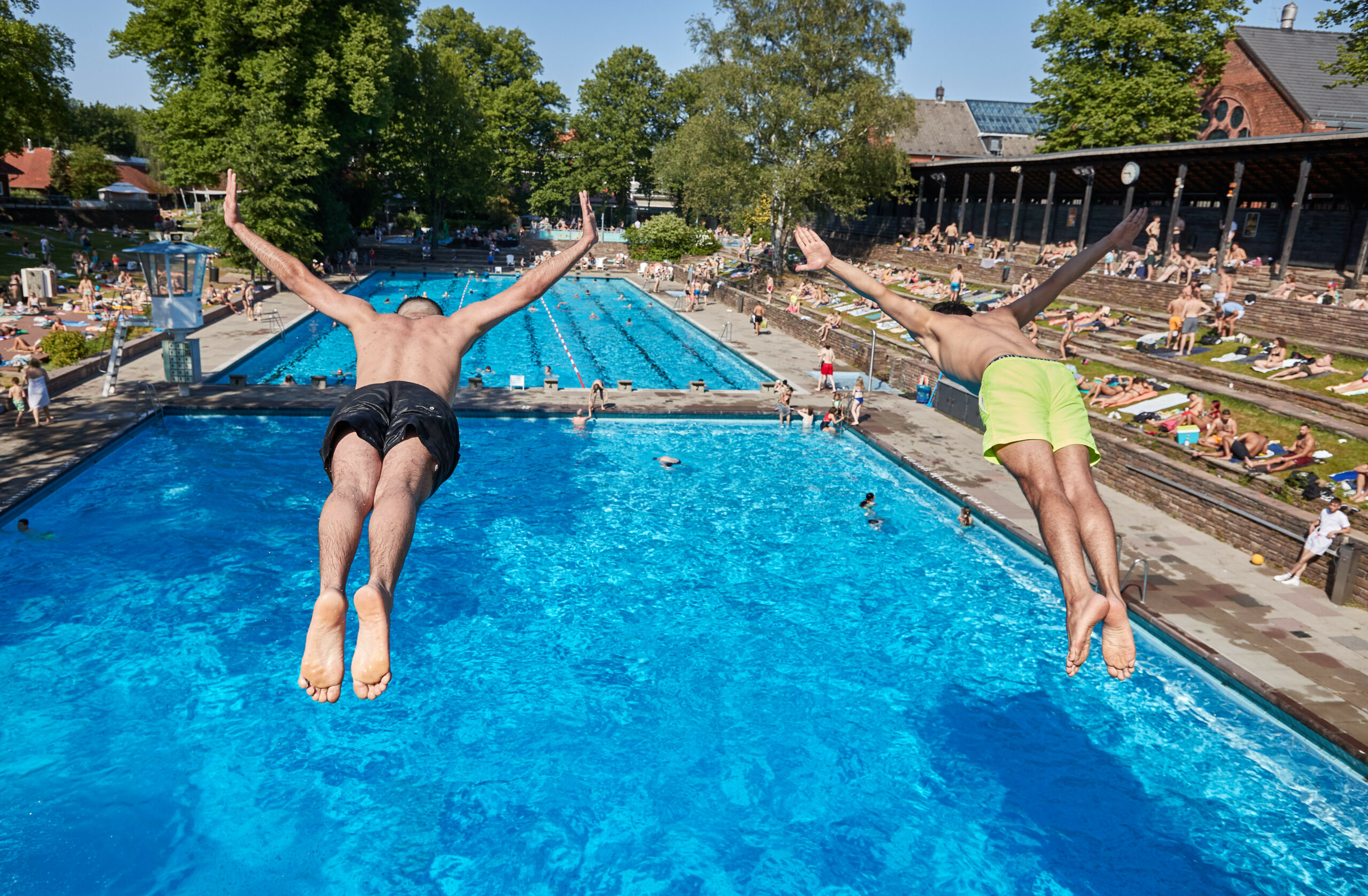 Männer springen ins Freibad