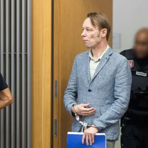 Der Angeklagte Christian B. (M) kommt mit Handschellen in den Gerichtssaal im Landgericht Braunschweig.