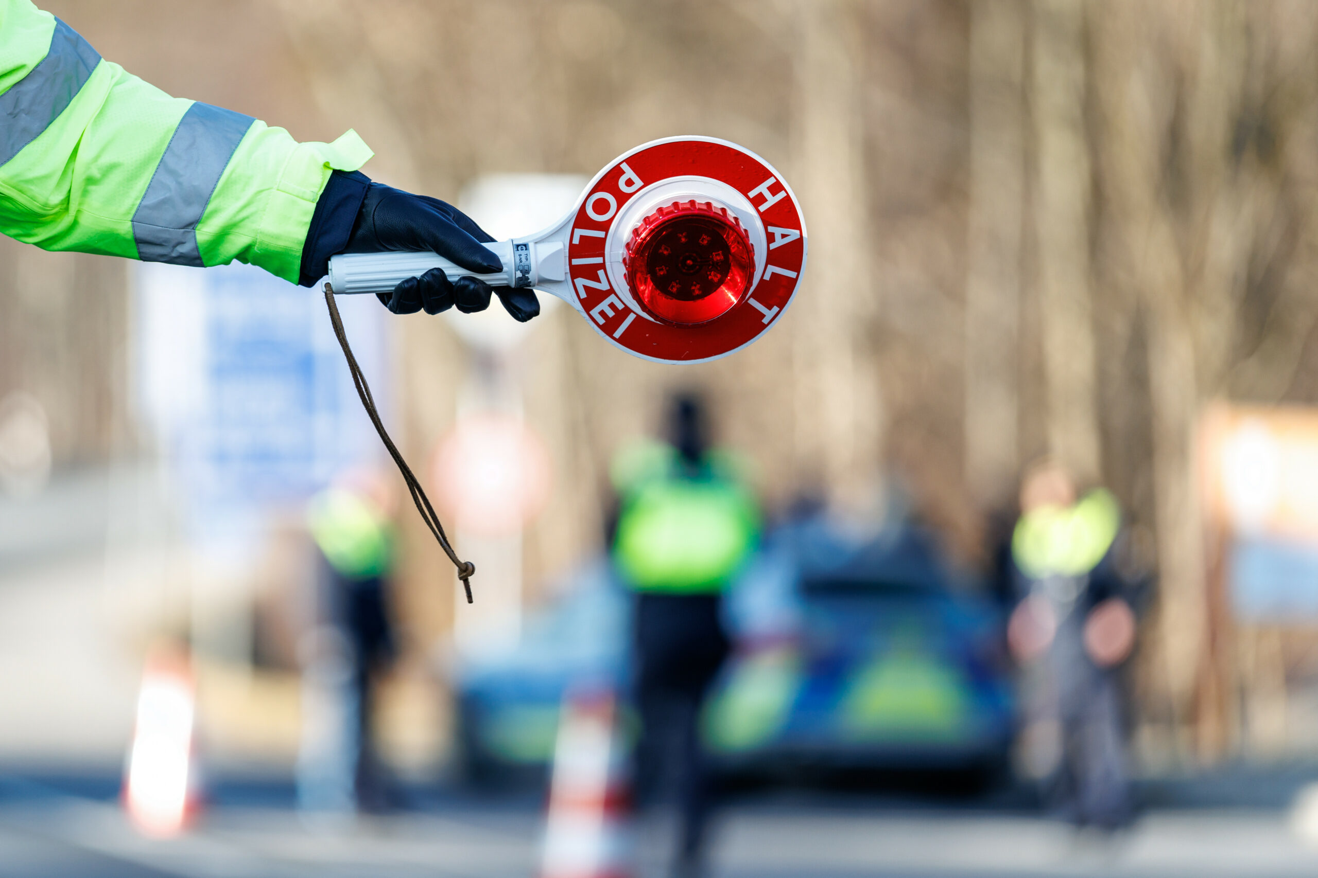 Ein Polizist winkt ein Auto in eine Kontrolle. (Symbolbild)