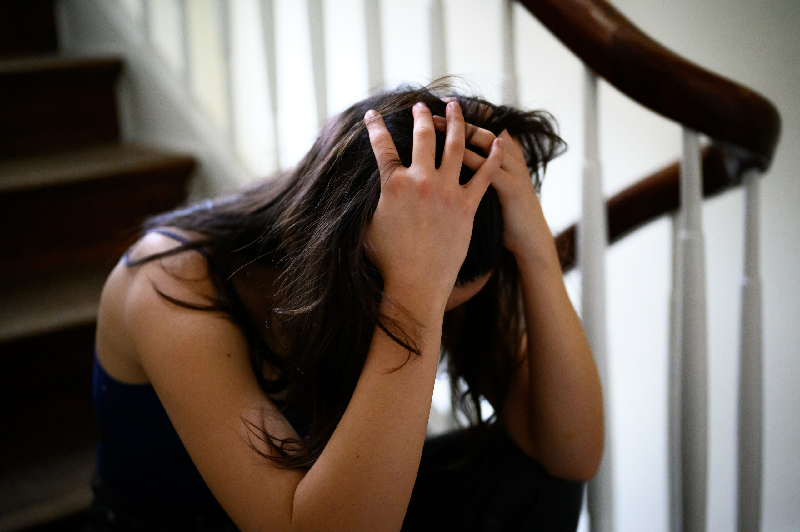 Frau stützt den Kopf in die Hände