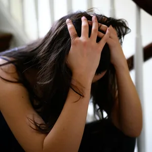 Frau stützt den Kopf in die Hände