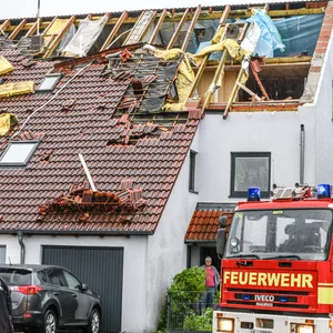 Einsatzkräfte von Feuerwehr und Polizei sind im Stadtteil Donaustetten im Einsatz, nachdem durch das Unwetter das Dach eines Reihenhauses stark beschädigt wurde.