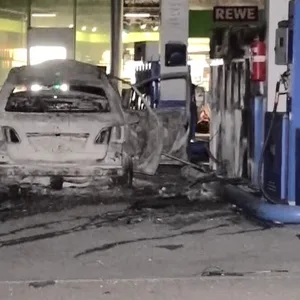 Mann fährt brennendes Auto an Tankstelle