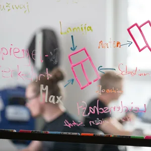 Mitarbeiter einer Start-up-Firma sitzen an ihren Arbeitsplätzen.