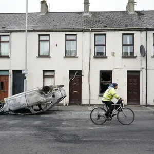Mann fährt in Ballymena an einem ausgebrannten, umgestürzten Auto vorbei