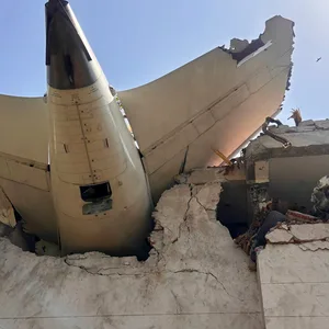 Das Heck des Flugzeugs steckt in einem Gebäude.