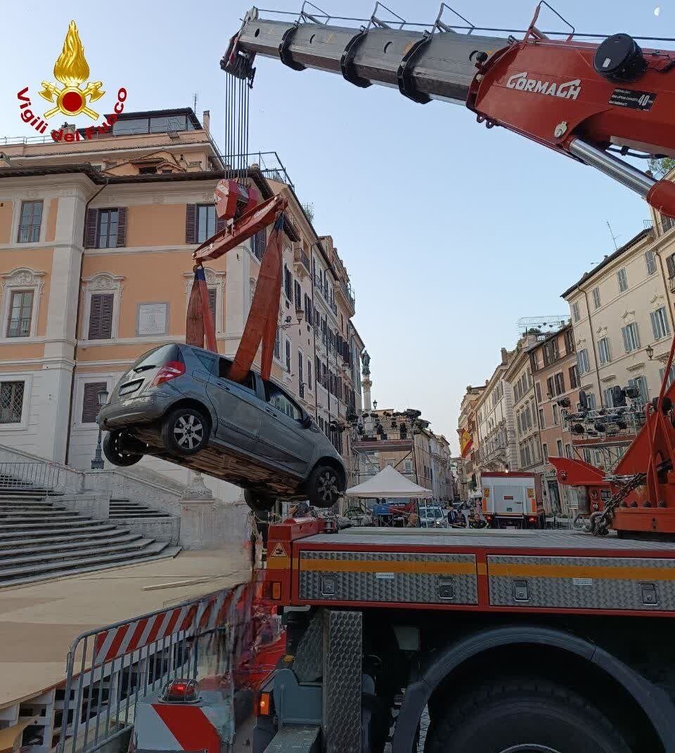 Ein Kran hebt ein Auto von der Spanischen Treppe.