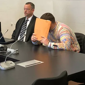 Der Angeklagte verbirgt sein Gesicht vor Gericht