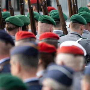 Soldaten laufen mit geschulterter Waffe während einer Veranstaltung.