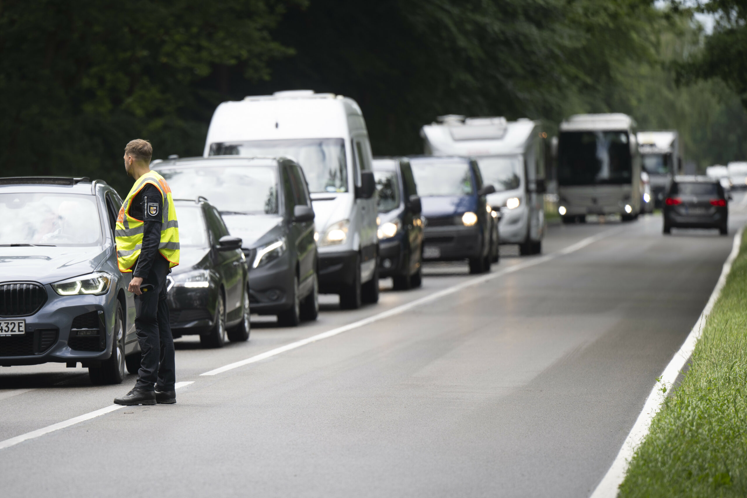 Ein Polizist kontrolliert Autofahrer, die zum Fusion Festival fahren.