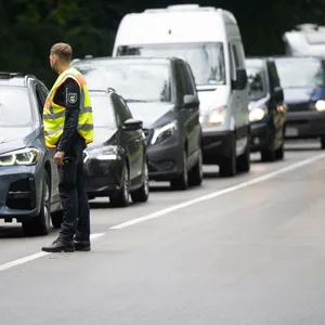 Ein Polizist kontrolliert Autofahrer, die zum Fusion Festival fahren.