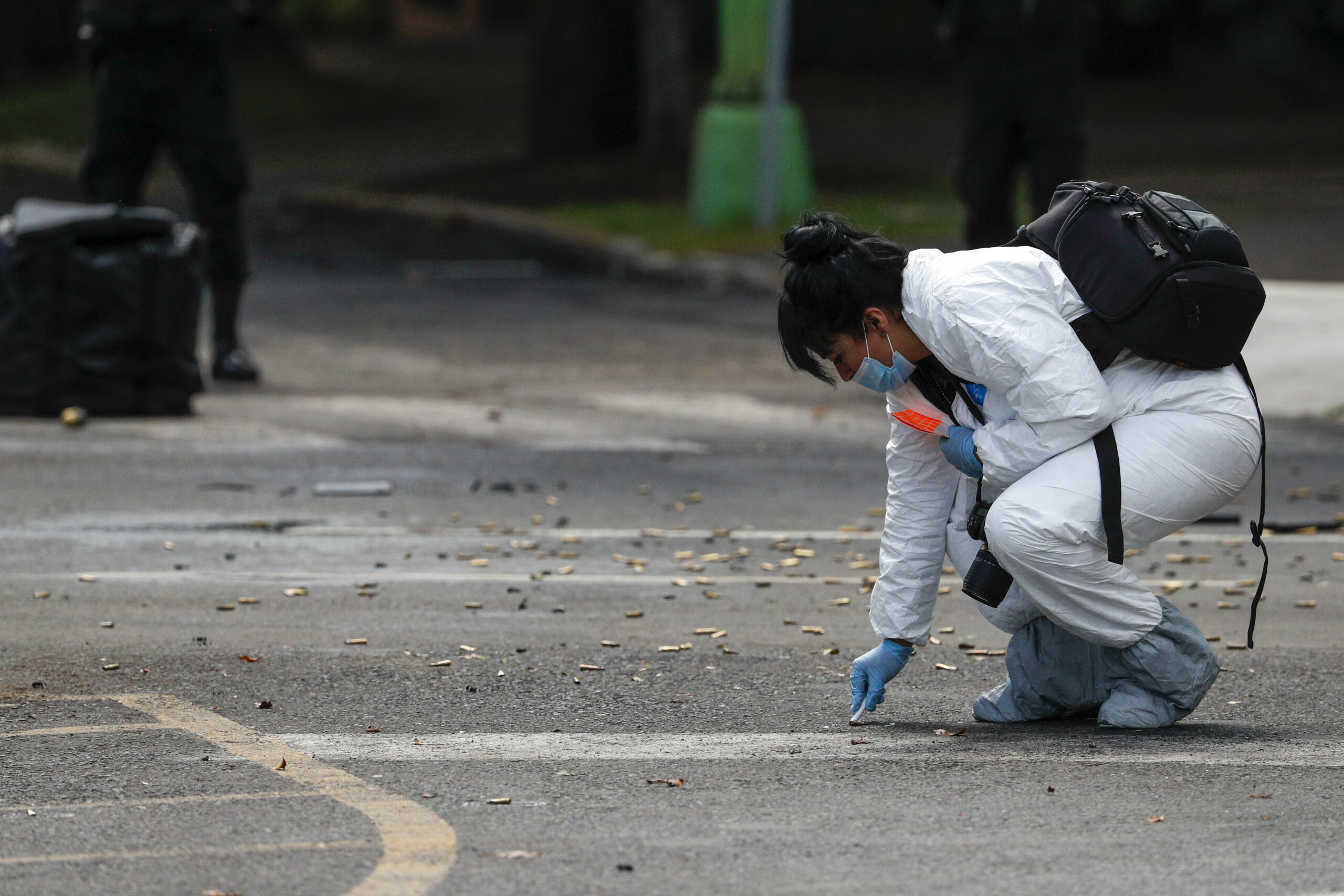Eine Mitarbeiterin der Forensik kniet neben zahlreichen Patronen nach einem Attentat gegen den Polizei-Chef von Mexiko-Stadt.
