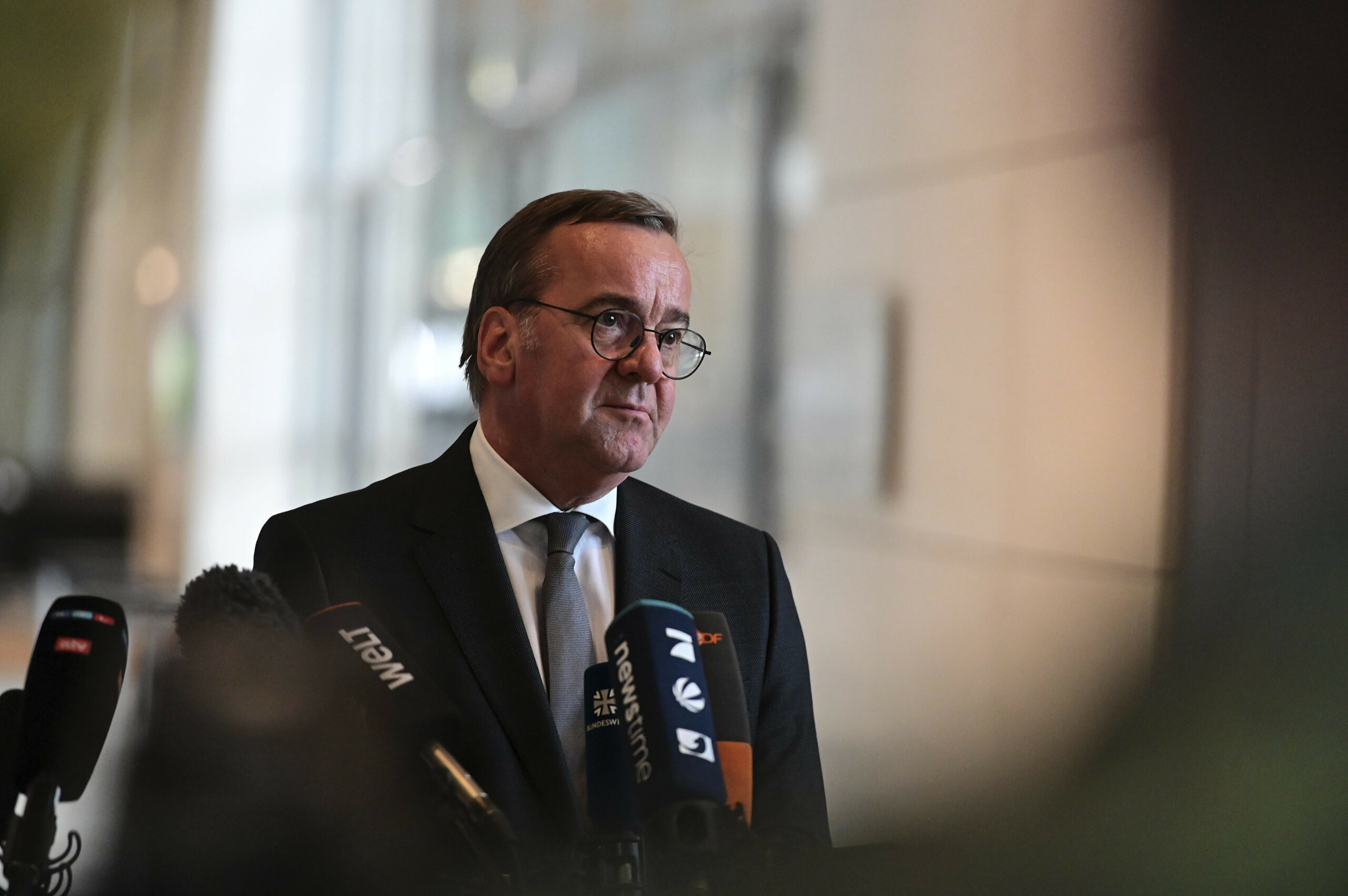 Pistorius steht vor mehreren Mikros von Medienvertretern.