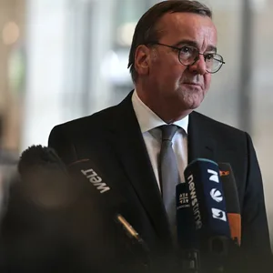 Pistorius steht vor mehreren Mikros von Medienvertretern.