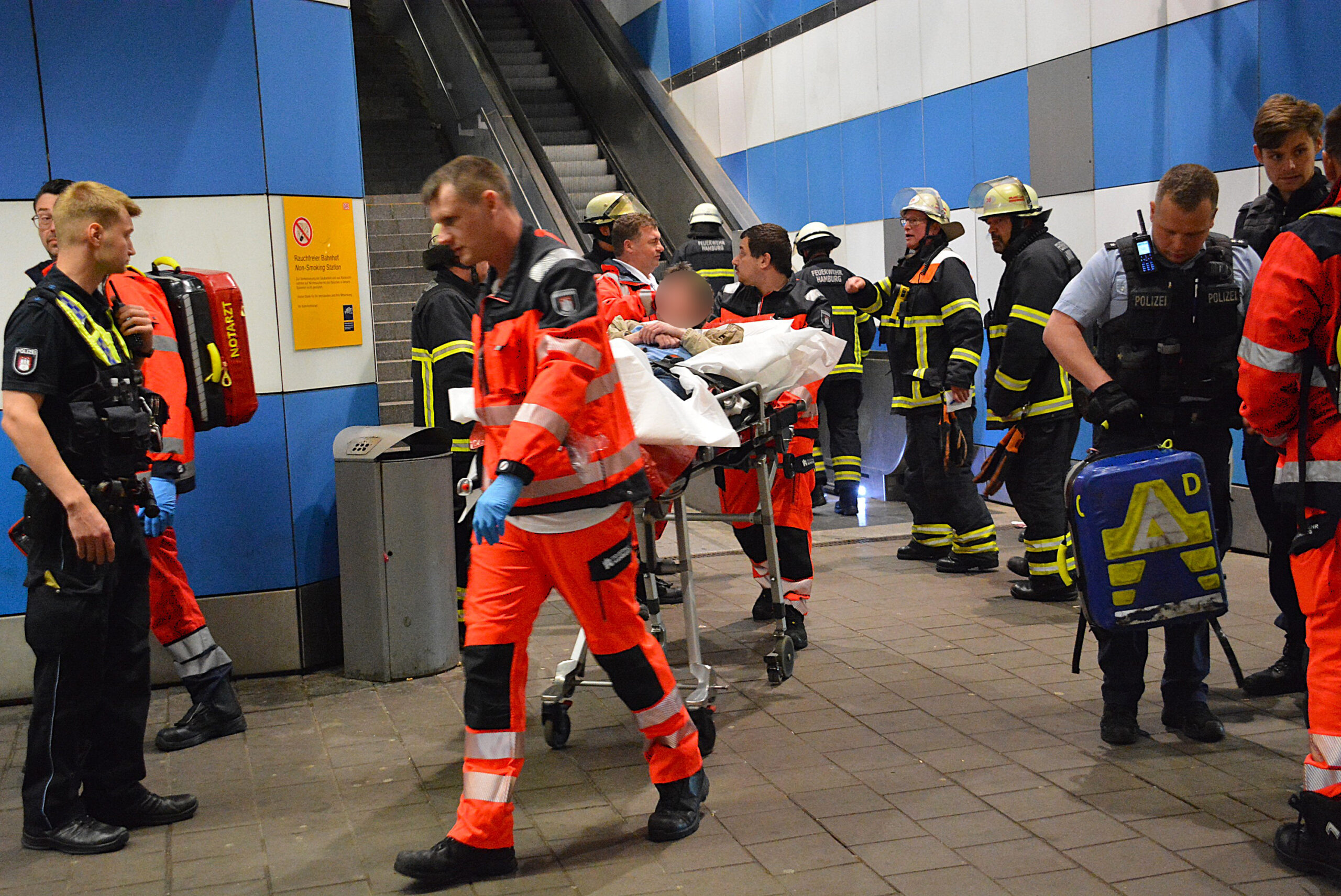 Sanitäter bringen den Betrunkenen am Bahnhof Allermöhe zum Rettungswagen.
