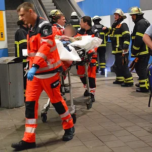 Sanitäter bringen den Betrunkenen am Bahnhof Allermöhe zum Rettungswagen.