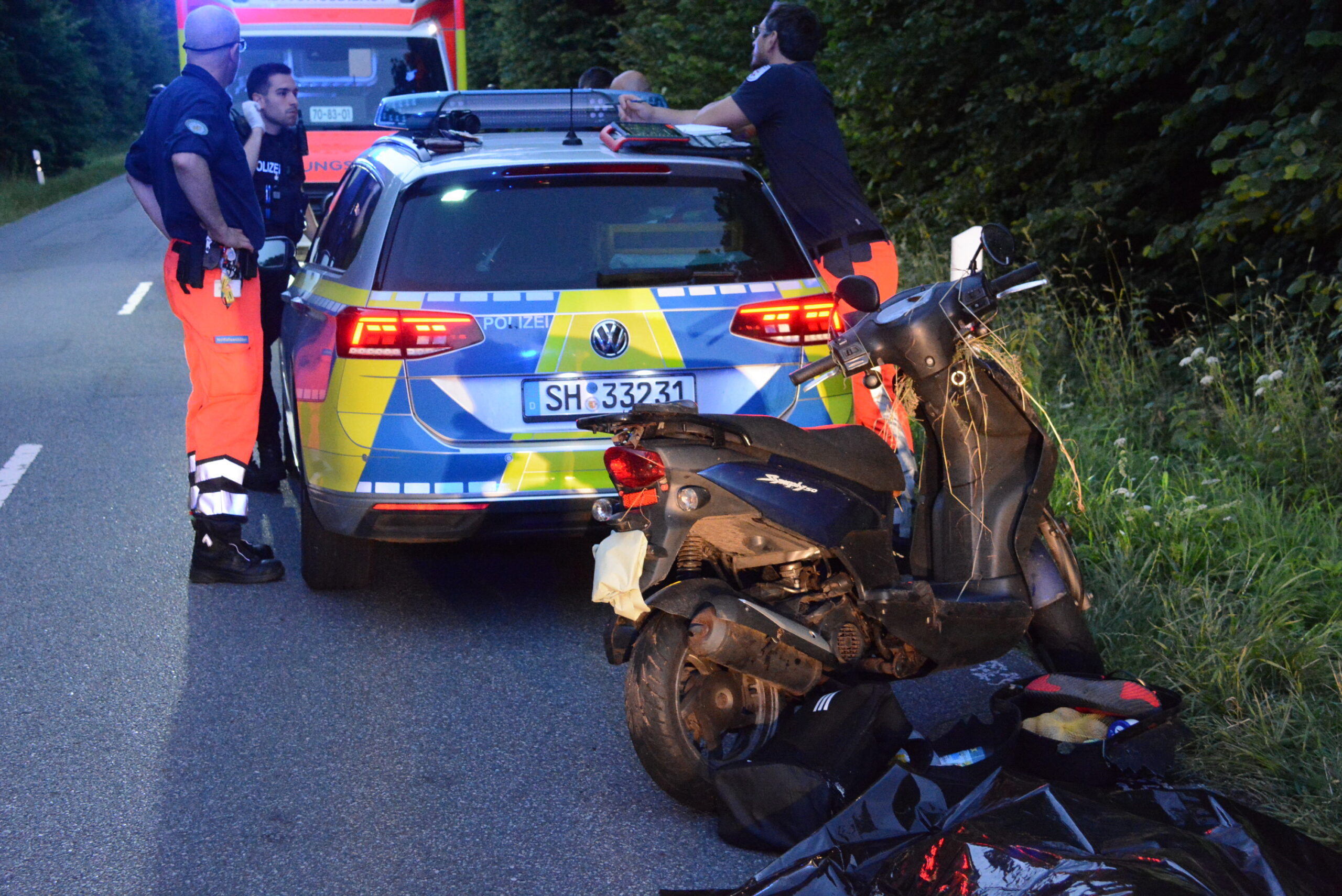 Der Roller des Verstorbenen steht vor einem Polizeiauto.