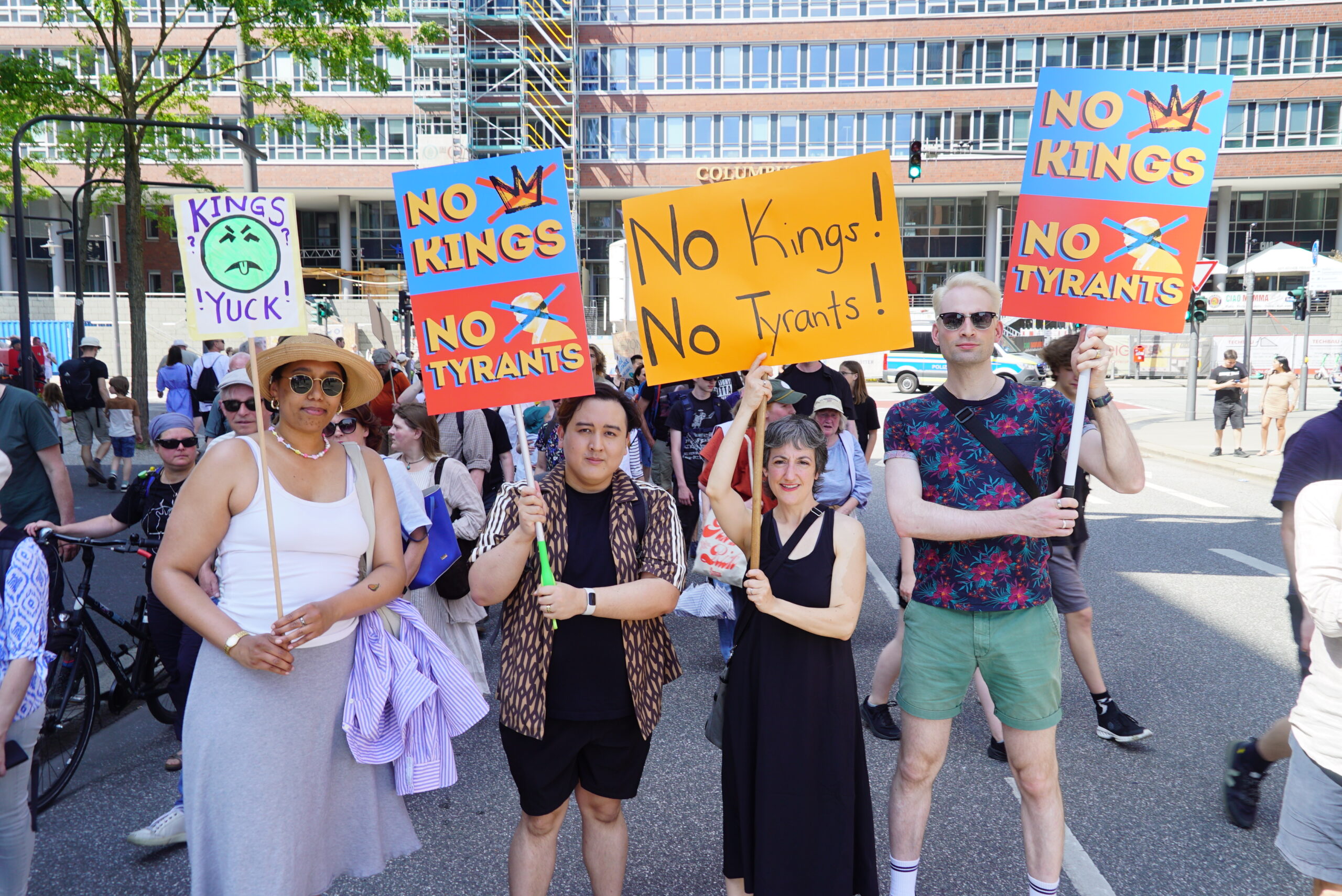 Menschen halten in Hamburg Demonstrationsschilder mit der Aufschrift „No Kings, No Tyrants“ hoch.