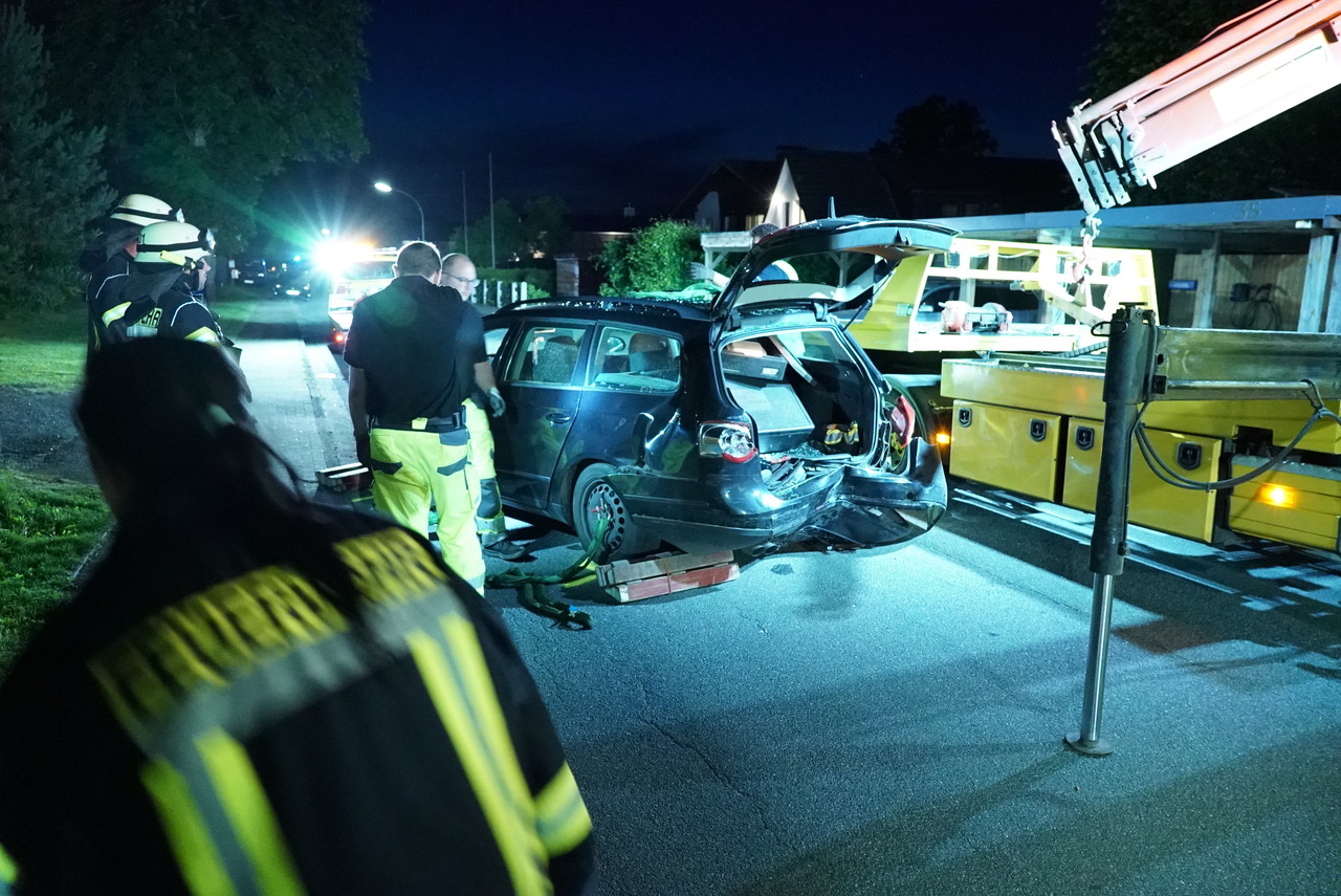 Feuerwehrleute stehen an dem verunglückten VW Passat.