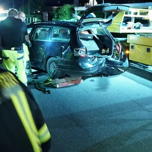 Feuerwehrleute stehen an dem verunglückten VW Passat.
