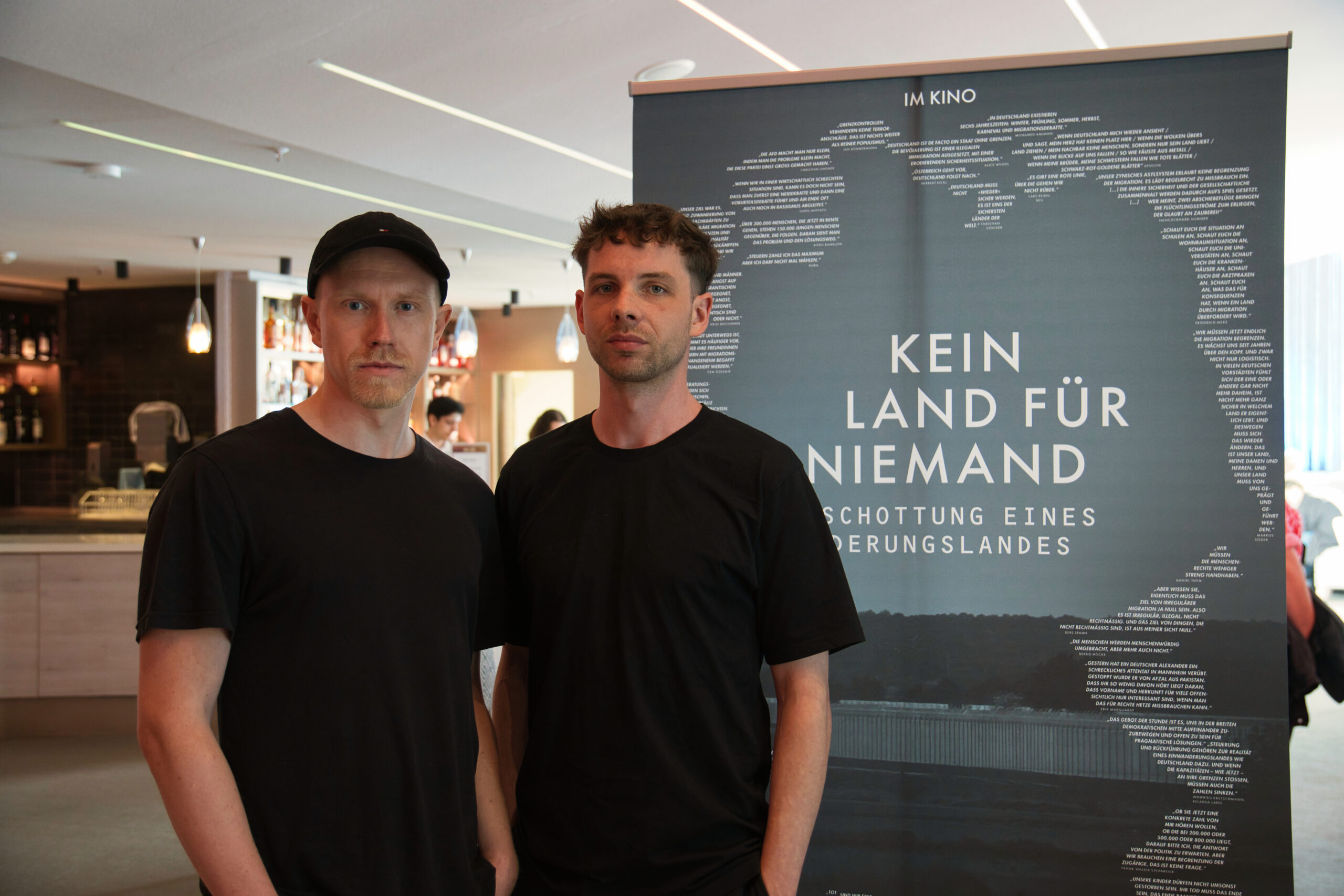 Zwei junge Männer vor Filmplakat