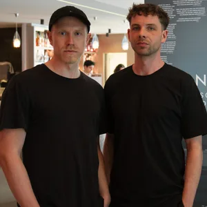 Zwei junge Männer vor Filmplakat