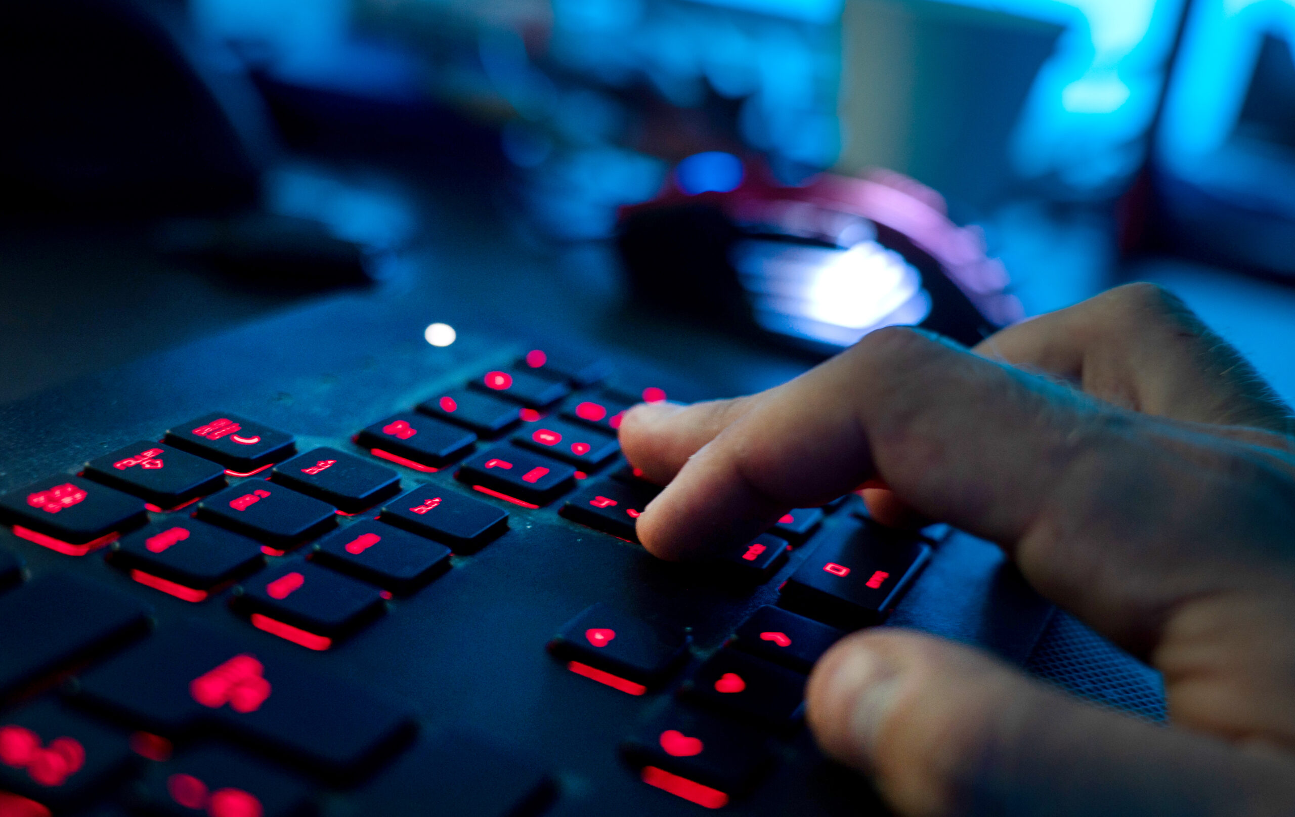 Ein Mann sitzt am Rechner und tippt auf einer Tastatur