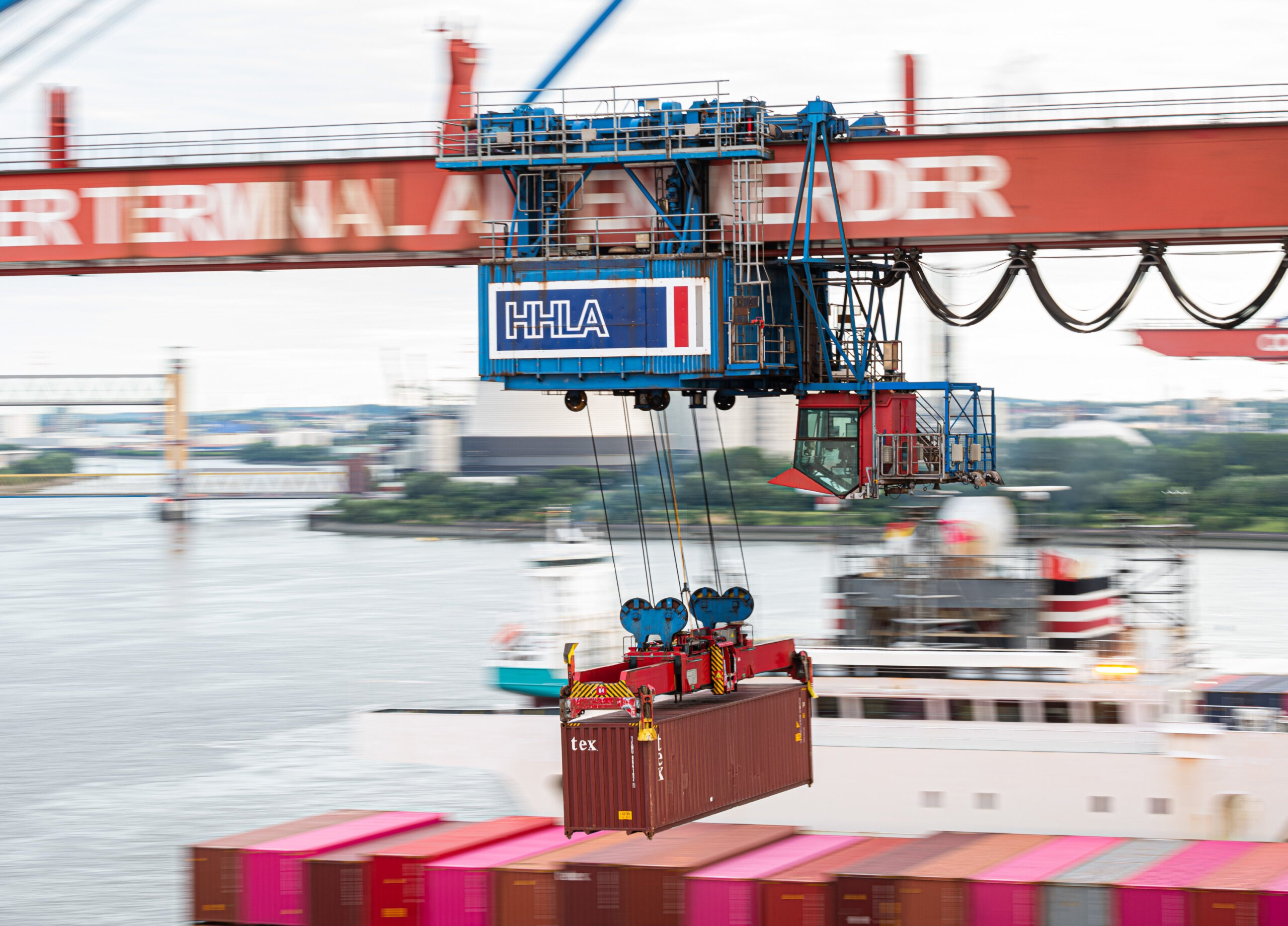 Ein Container wird auf dem HHLA-Container-Terminal Altenwerder im Hamburger Hafen mit einer Containerbrücke auf ein Schiff geladen.