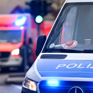 Ein Polizeiauto und ein Rettungswagen mit Blaulicht.