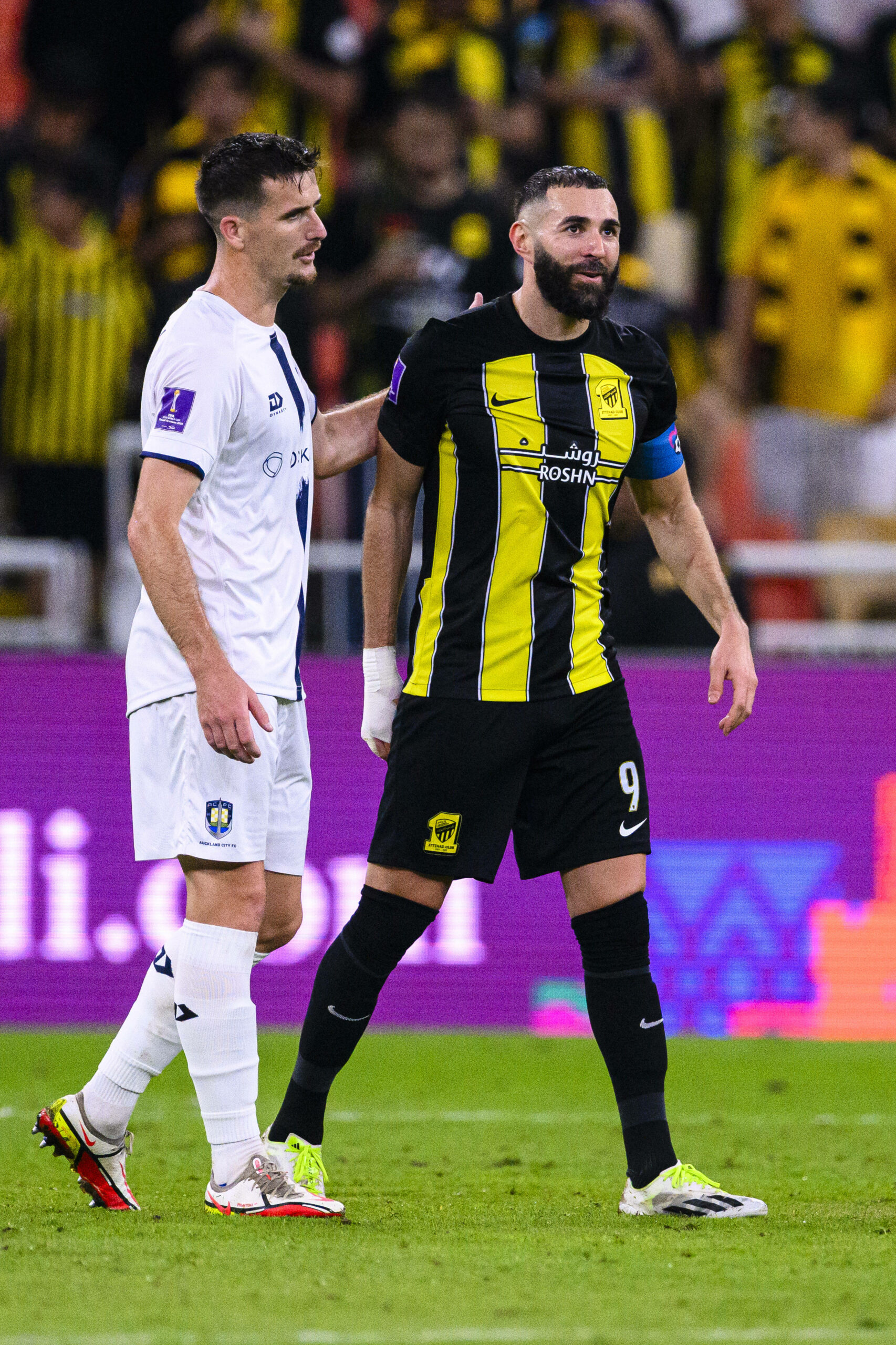 Angus Kilkolly neben Karim Benzema auf den Spielfeld