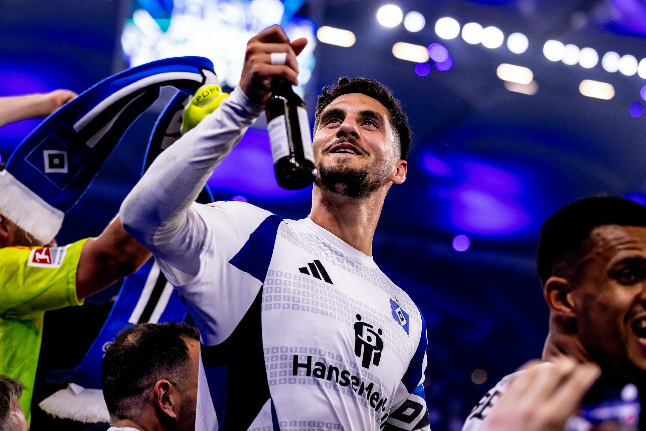 Ludovit Reis hält ein Bier in Richtung der HSV-Fans
