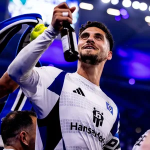 Ludovit Reis hält ein Bier in Richtung der HSV-Fans