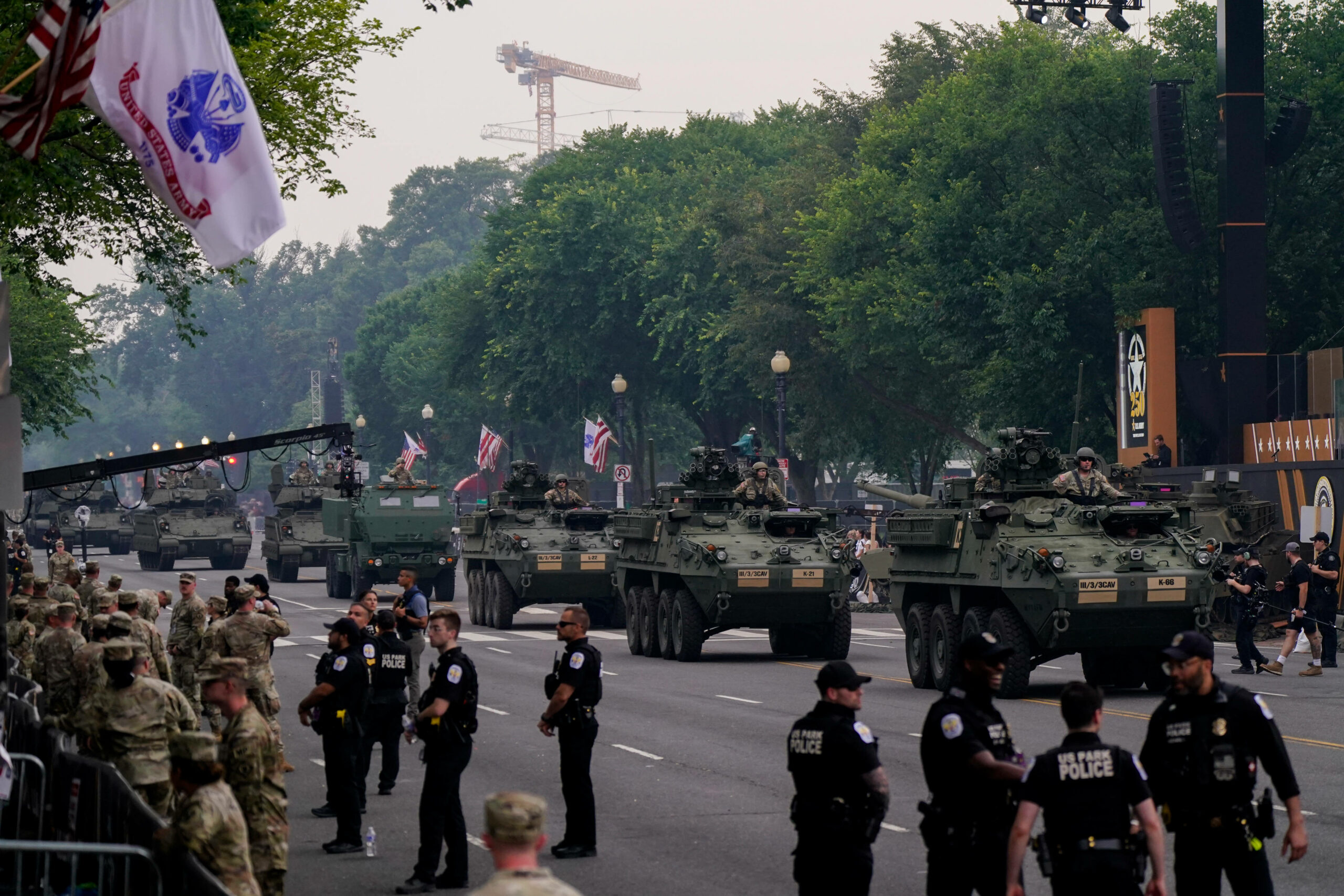 Soldaten fahren während einer Parade mit Panzern auf einer Straße.