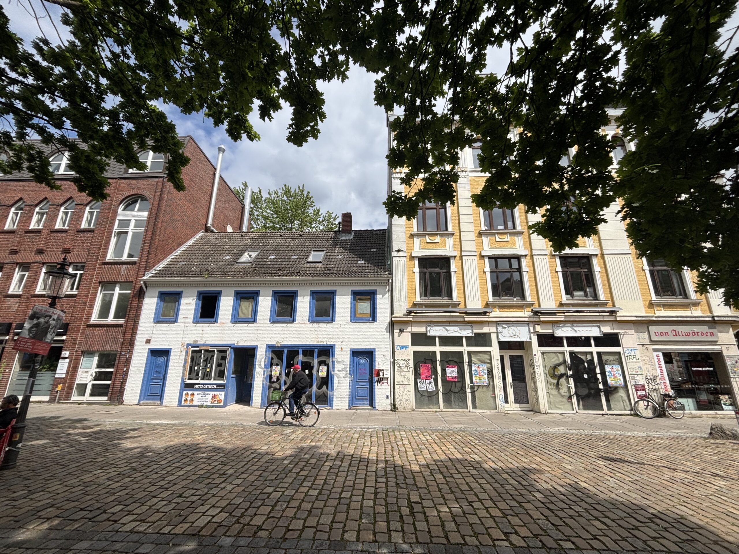 Kleines weißes Haus mit blauen Läden