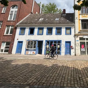 Kleines weißes Haus mit blauen Läden