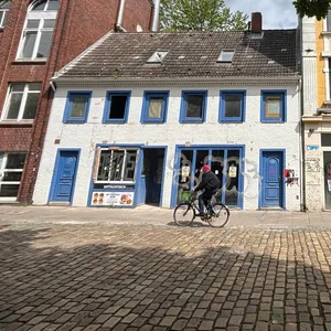 Kleines weißes Haus mit blauen Läden