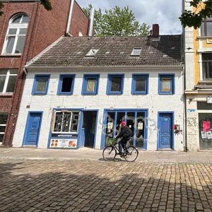 Kleines weißes Haus mit blauen Läden
