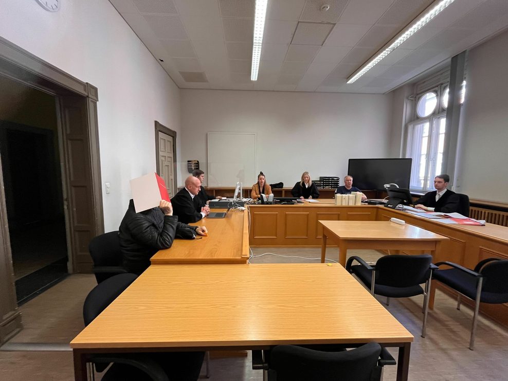 Gerichtssaal 263 im Strafjustizgebäude: Der Angeklagte Patrik D. hält sich als Schutz vor den Kameras einen Aktenordner vors Gesicht.