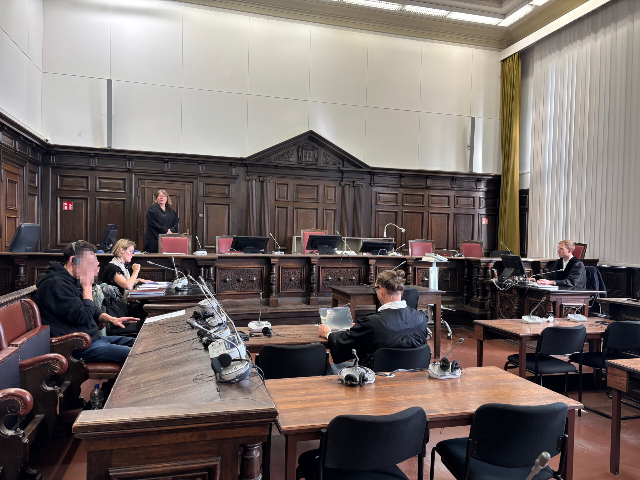 Der Angeklagte D. (l.) neben der Dolmetscherin und seinem Anwalt im Gerichtssaal des Strafjustizgebäude Hamburg.
